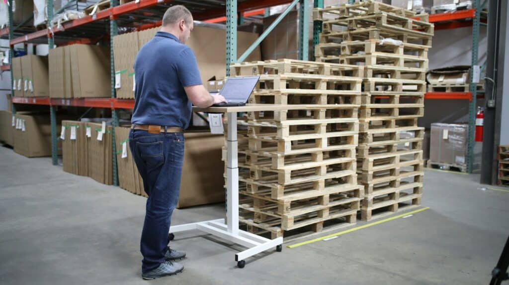 Warehouse employee using order management software to verify inventory and fulfillment status.